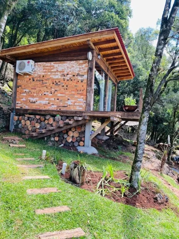 Cabana rústica elevada com tijolos e madeira